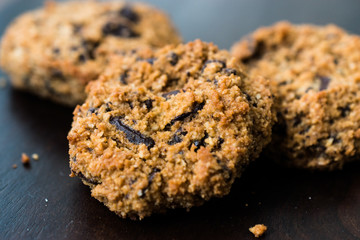 Paleo Chocolate Chip Cookies Made with Coconut and Almond Flour on Dark Wooden Board.