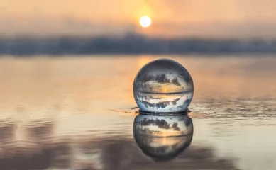 Fotobehang Glazen bol op het strand bij zonsondergang © Andreas Ardler