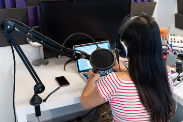 Rear view of a woman long hair working at the radio station.