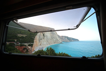 View of the beach and the turquoise sea of Porto Katsiki from inside a camper van