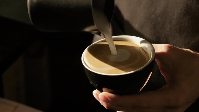 Barista making of cafe latte art, heart shape. Making Cappuchino in Coffeeshop