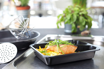 Takeaway dish. Grilled salmon fillet on pasta.