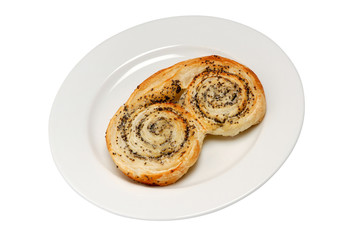 Sweet layered baked buns with poppy seeds and honey filling inside. Dessert pastry on plate isolated on white.