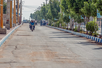 11/05/2019 Hormuz, Hormozgan Province, Iran, motorcyclists ride along the avenue on a sunny and hot day.