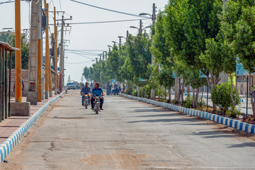 Fototapeta na wymiar 11/05/2019 Hormuz, Hormozgan Province, Iran, motorcyclists ride along the avenue on a sunny and hot day.