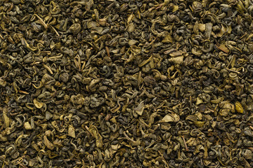 Dry oolong tea leaves as a background. Shot from above.