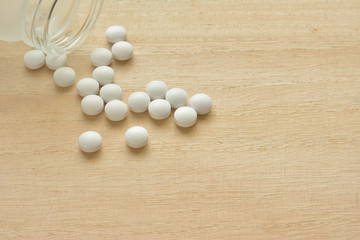 White pills on a wood table