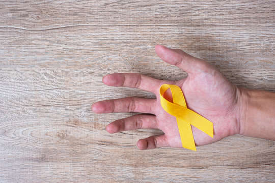 Suicide prevention and Childhood Cancer Awareness, Yellow Ribbon for supporting people living and illness. children Healthcare and World cancer day concept