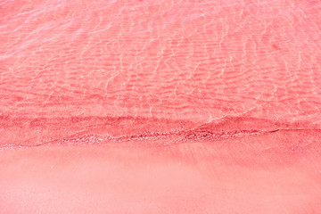 Beach background with sea wave. Texture sand. Vintage coral pink filter. Relax atmosphere.