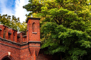 Part of a brick defensive structure against a background of trees and sky
