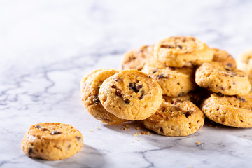 Pile of chocolate chip cookies on marble stone background. Selective focus. Copy space.