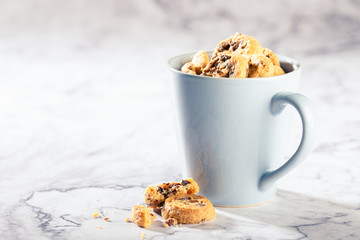 Chocolate chip cookies in blue cup on marble stone background. Selective focus. Copy space. Toned.