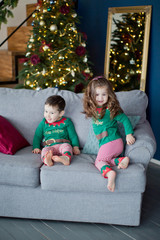 Fototapeta na wymiar Cute children brother and sister elves, Santa's little helpers with a Christmas magic gifts