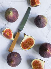 ripe figs with a knife on a marble table