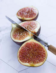 ripe figs with a knife on a marble table