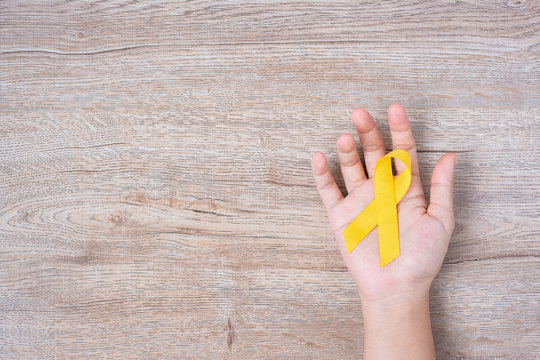 Suicide prevention and Childhood Cancer Awareness, Yellow Ribbon for supporting people living and illness. children Healthcare and World cancer day concept