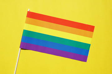 rainbow flag on yellow background - lgbt or gay pride symbol - lesbian homosexual bisexual transgender queer