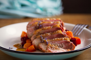 Sliced duck breast fillet with sweet potatoes and  beetroot on plate