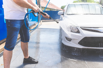 Man hand using car wash water spray high pressure machine for car wash