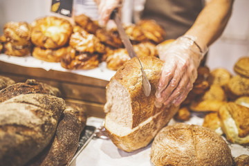 Man hands slicing home made bread.