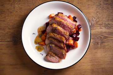Sliced duck breast fillet with sweet potatoes and  beetroot on plate