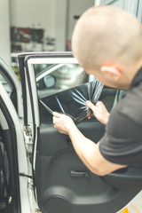 Process of removing glass protection tinted foil from side car window.