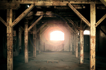 Old wooden columns. Old abandoned warehouse, illuminated by light from the window.