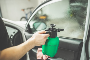 Worker tinting car window in shop