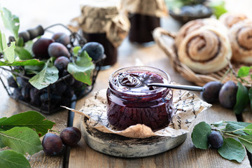Sweet homemade plum jam and fruits on a wooden table