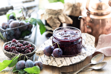 Sweet homemade plum jam and fruits on a wooden table