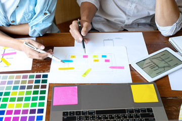 Group of young designer working in the office to design a new product, use color chart and computer...