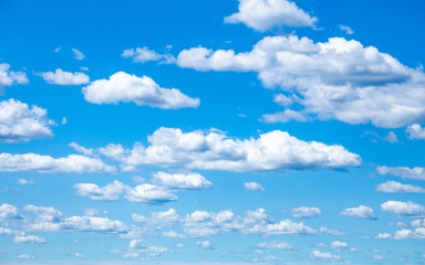 Nice small clouds. Cute fluffy cirrus clouds on a blue sky, background with a gradient effect. Postcard cloudscape