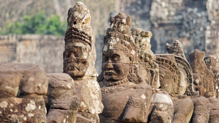 Row of sculptures in the South Gate of Angkor Thom complex. Siem Reap, Cambodia