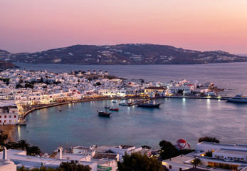 View to the town of Mykonos island just after a colorful summer sunset with illuminated houses and streets, Cyclades, Greece