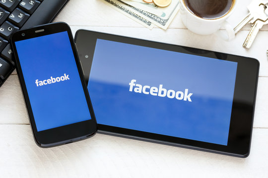 Facebook Social Network Logo On New Tablet And Smartphone