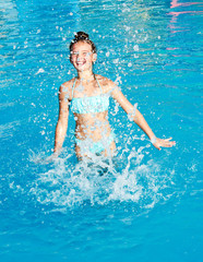 Cute smiling little girl child having fun in the swimming pool