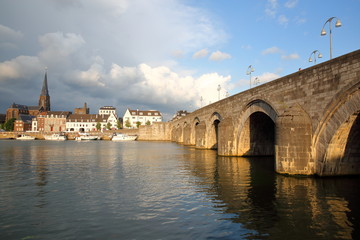 Wyck neighborhood ( Sint Martinuskerk church) and the 13th century roman bridge Sint Servaasbrug (on the right) viewed from the western banks of the Meuse river at sunset, Limbourg, Maastricht, Nether