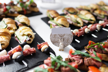 tasty and delicious catering stands on stone trays and on white wooden tables