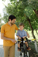 Bicycle ride of father and his son on baby seat
