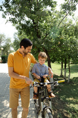 Bicycle ride of father and his son on baby seat
