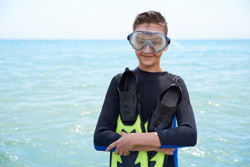 BOYS OF TEENAGERS IN A DIVING BLACK SUIT WITH A DIVING MASK AND FLIPPERS