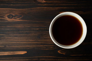 Soy sauce and soy bean on wooden table.