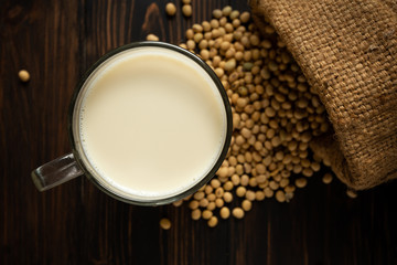 Soy milk and soy bean on wooden table background.