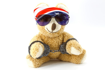 Plush bear with handcuffs on hand