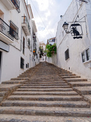 Beautiful narrow street among white houses in Altea. Costa Blanca, Spain.