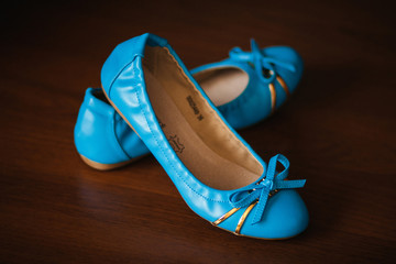 Pair of blue leather ballet flats on wooden background