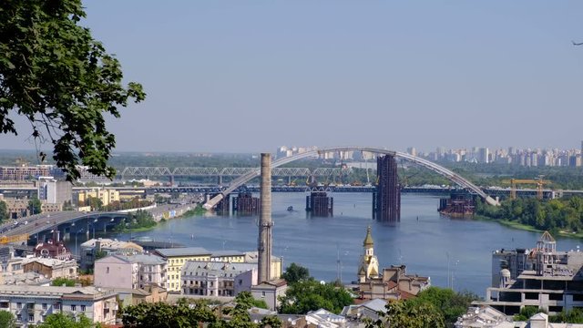 Panoramic video picture cityscape top view of the embankment from the right bank of the Dnieper in Kiev, Ukraine, 08/19/2019 district of the river station, Podil and the bridge under construction, hig