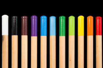 Row of colorful colored pencils against a black background. LGBT