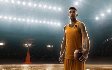 Professional basketball player in sports uniform on basketball court with a ball