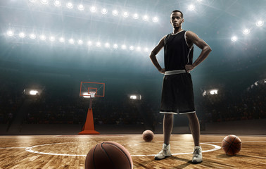 African american professional basketball player in sports uniform on basketball court with a ball